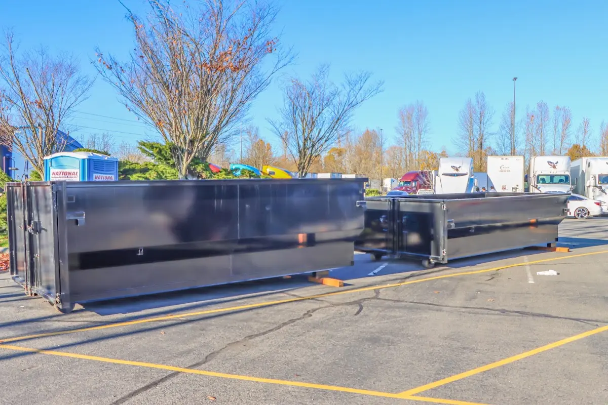 Professional dumpster rental service with roll-off container on residential driveway in Kalispell